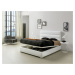 Estila Moderná kožená posteľ Lidia s čalúnením bielej farby s vysokým čelom a s úložným priestor